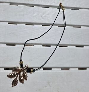 black cord necklace with metallic leaf pendant, gold and black beads